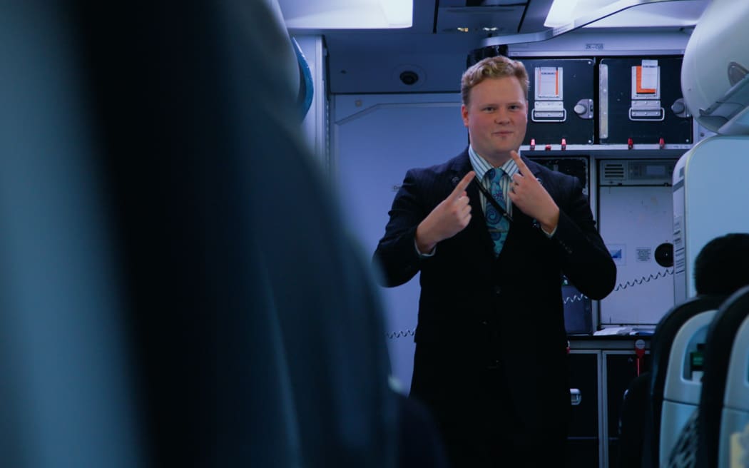 An Air NZ cabin crew member signs passenger announcements on board NZ421 from Auckland to Wellington on 6 May 2024.