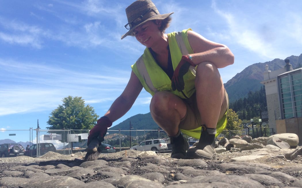 Archaeologist Dr Andrea Farminer brushes down the old Eichardt's Hotel stable floor.