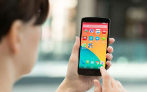 Kiev, Ukraine - September 14, 2014: Woman using a brand new Google Nexus 5 outdoors.