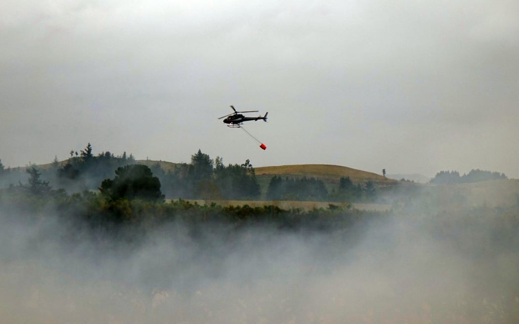 A helicopter with a monsoon bucket at work in Canterbury.