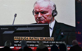 Former Bosnian Serb military chief Ratko Mladic (C) appears on the screen of a live television broadcast from The Hague in the Netherlands.