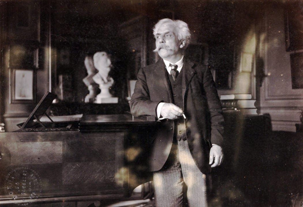 Gabriel Fauré next to his piano, in his appartement in the boulevard Malesherbes, Paris