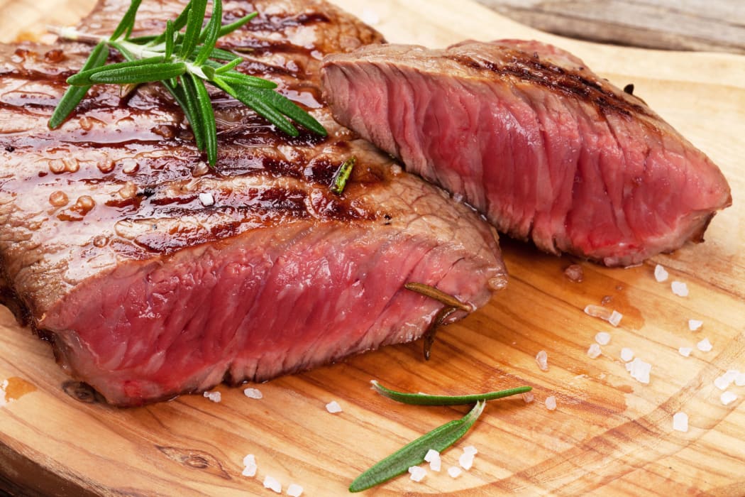 50344317 - grilled beef steak with rosemary, salt and pepper on cutting board