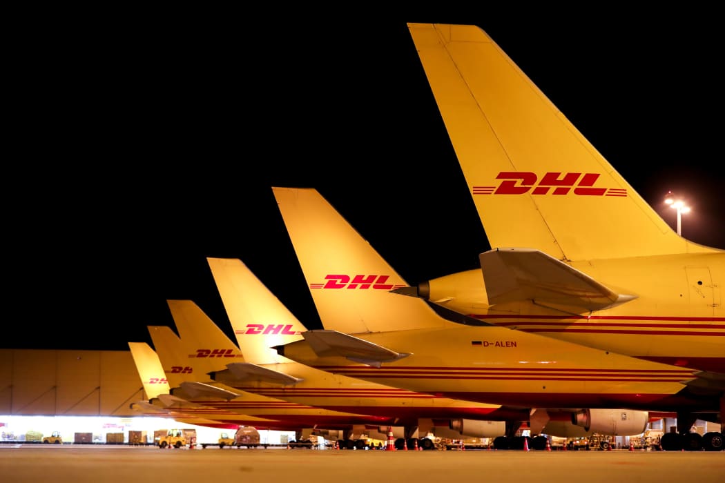 DHL cargo aircraft are unloaded at Leipzig/Halle Airport at night.