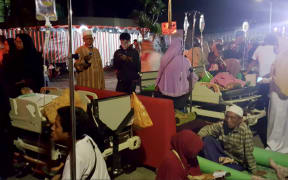 Hospital patients and relatives wait outside after being evacuated after an earthquake rocked Indonesia's Lombok island.