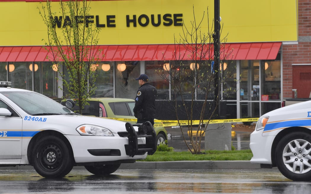 NASHVILLE, TN - APRIL 22: Law enforcement stand outside a Waffle House where four people were killed and two were wounded after a gunman opened fire with an assault weapon on April 22, 2018 in Nashville, Tennessee.