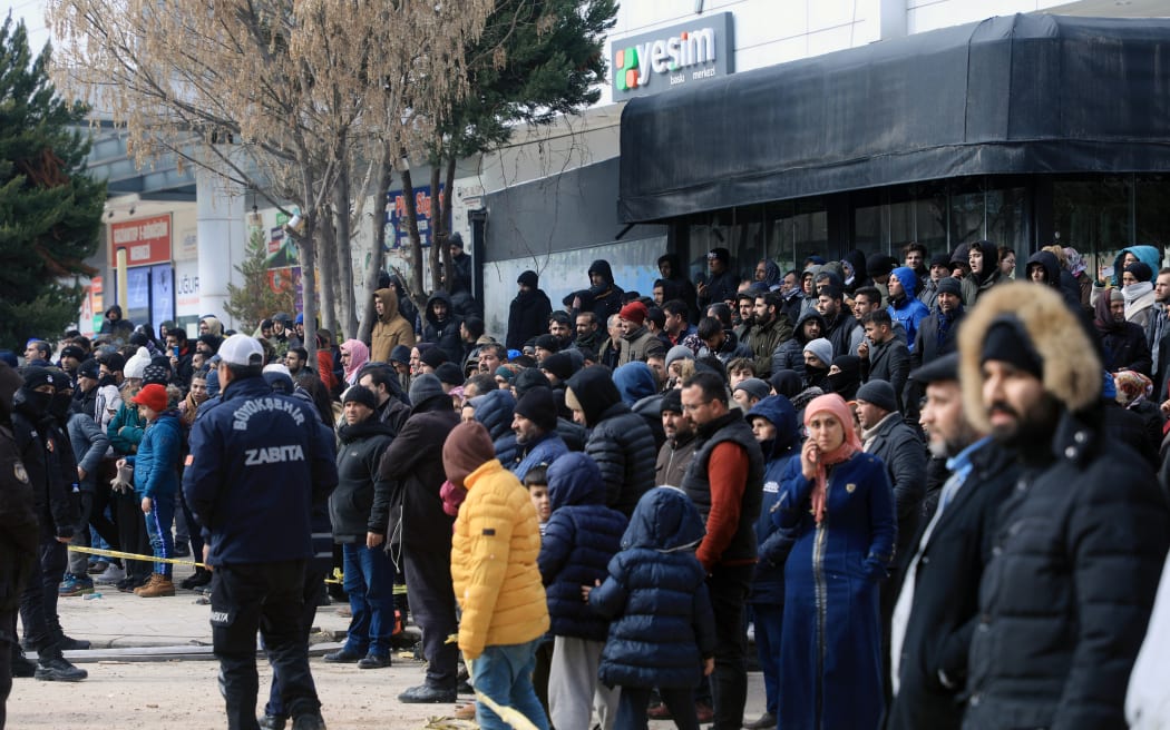 Onlookers and relatives gather around a cordonned-off area in Gaziantep, close to the quake's epicentre, a day after a 7.8-magnitude earthquake struck Türkiye, on February 7, 2023.