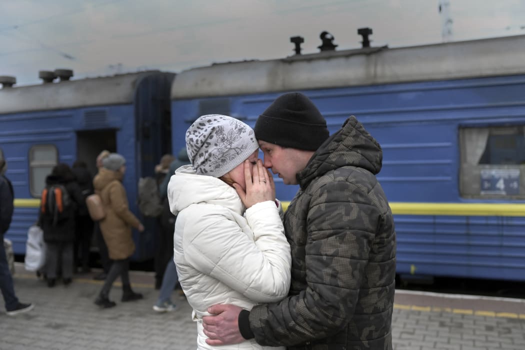 A couple embrace as they stand in front of an evacuation train at the central train station in Odessa on 6 March, 2022.