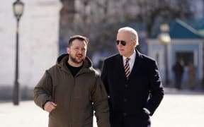 US President Joe Biden (R) walks next to Ukrainian President Volodymyr Zelensky (L) as he arrives for a visit in Kyiv on 20 February, 2023.,