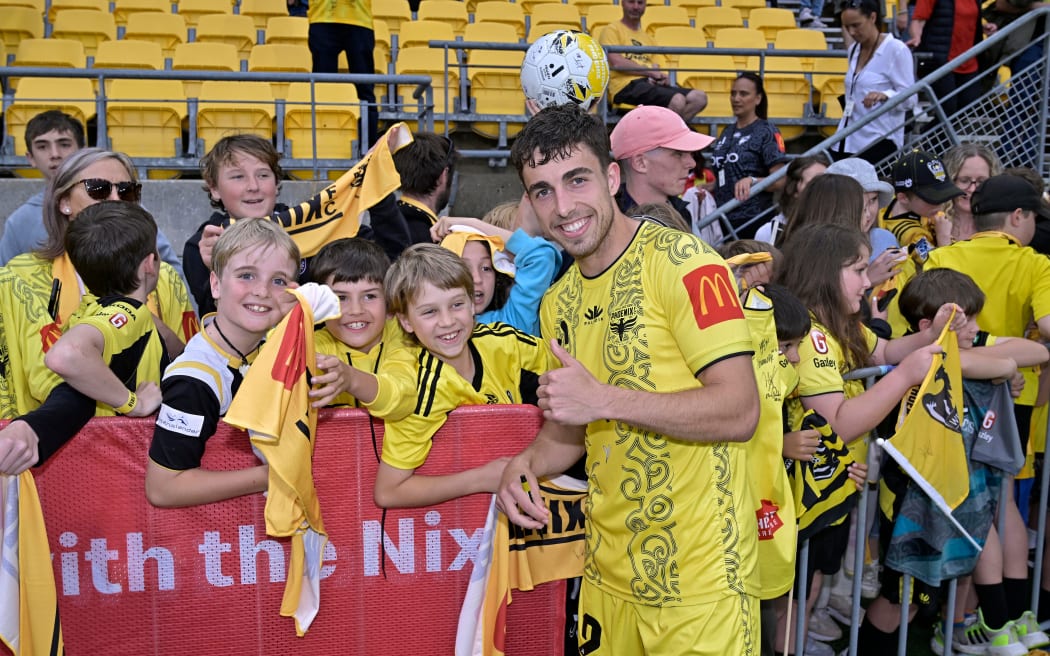Sam Sutton of the Phoenix poses for a photo with fans after their match against Western Sydney Wanderers at Sky Stadium.