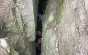 Only the feet of a woman trapped between two boulders can be seen in this image released by NSW Ambulance.