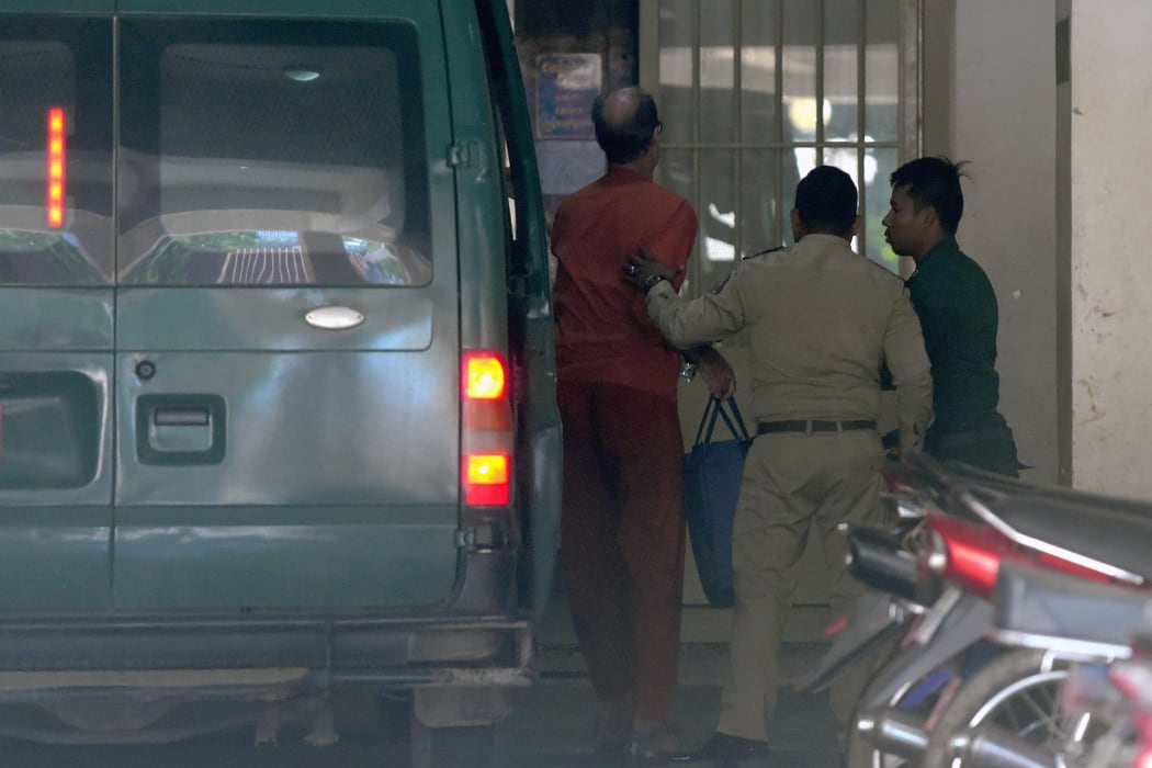Australian filmmaker James Ricketson (L) exits a prison vehicle as he arrives at court to hear his verdict in Phnom Penh.