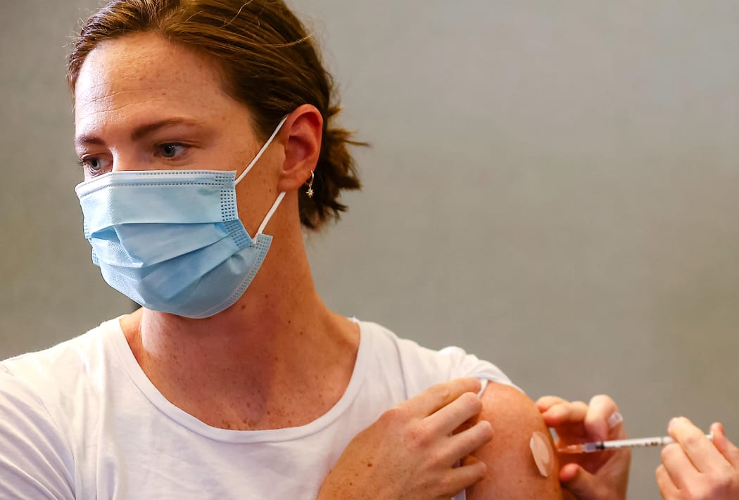 Three time Olympian Australian swimmer Cate Campbell (L) receives her dose of Pfizer/BioNTech vaccine against Covid-19 at the Queensland Sports and Athletics Centre in Brisbane on May 10, 2021,