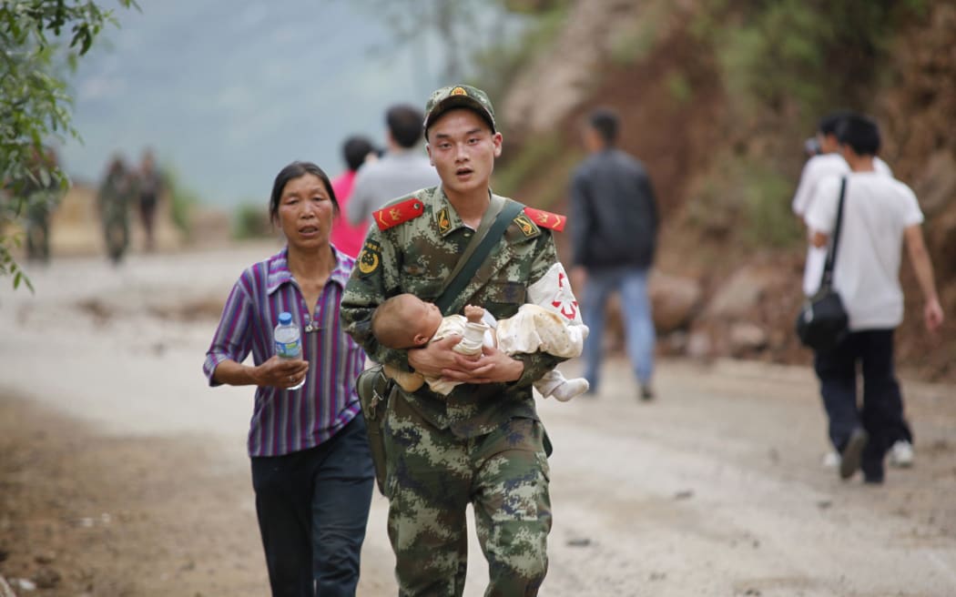 A rescuer carries a baby after a deadly earthquake hit in China's Yunnan province.