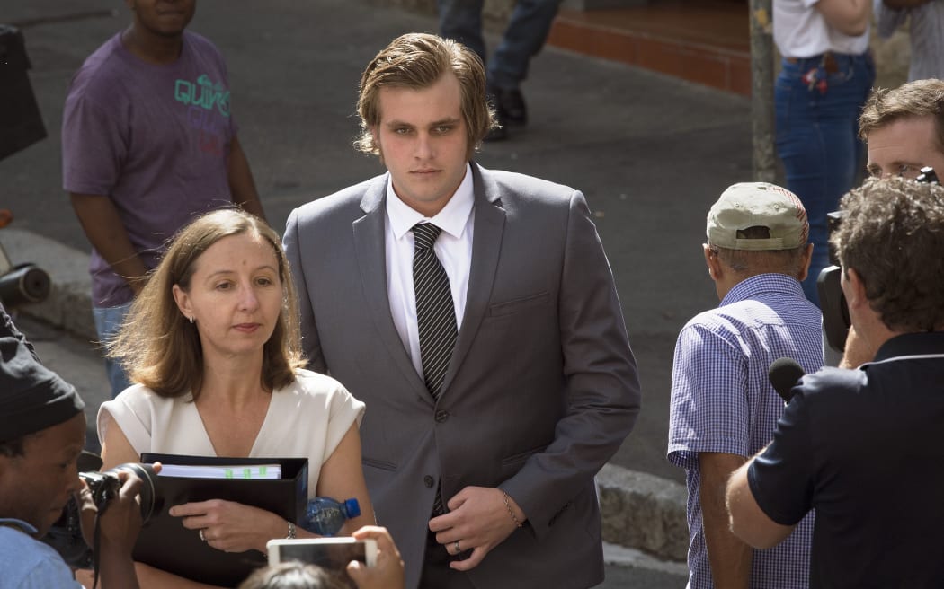 Henri van Breda (C) arrives with his lawyer Lorinda van Niekerk (L) at the Western Cape High Court for the start of his trial for allegedly killing his two parents, brother, and wounding his sister, with an axe, in their luxury home, on March 27, 2016, in Cape Town.