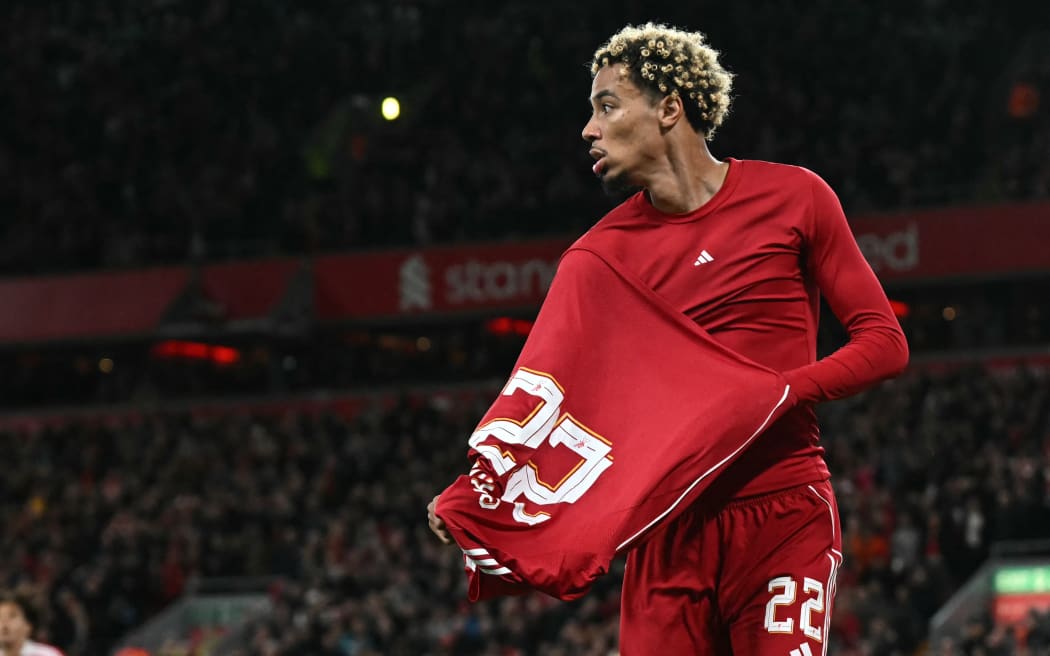 Liverpool striker Hugo Ekitike starts to remove his shirt as he celebrates scoring their second goal, before being sent off for a second yellow card in the English League Cup third round match against Southampton at Anfield. September 23, 2025. (Photo by Paul ELLIS / AFP)