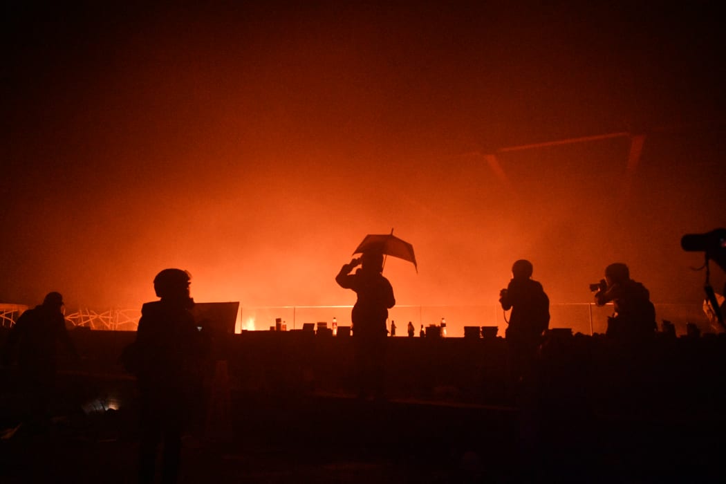 A large fire burned near an entrance to a besieged Hong Kong campus on November 18 morning after protesters threw Molotov cocktails to fend off a police advance on the university, according to AFP reporters at the scene.
