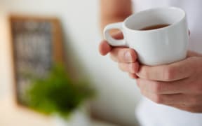 Image of cup of tea in male hands