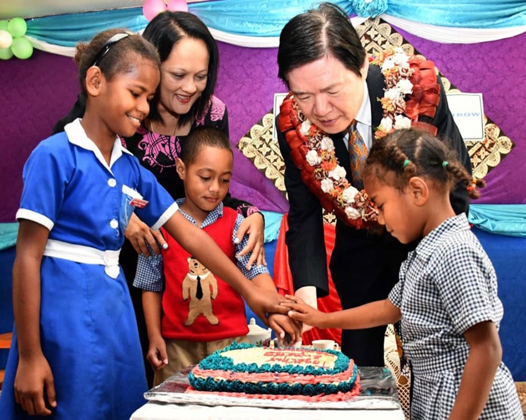 Fiji's Education Minister Rosy Akbar and Japanese Ambassador Omura Masahiro with children of Naivicula District School in Tailevu.