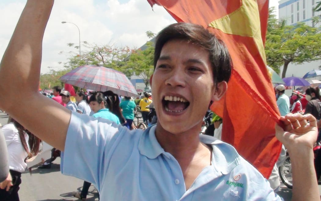 A protester shouts slogans and waves a Vietnamese flag in Binh Duong.