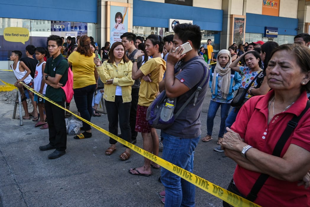 People gather outside a mall after a hostage situation was reported in suburban Manila on 2 March, 2020.