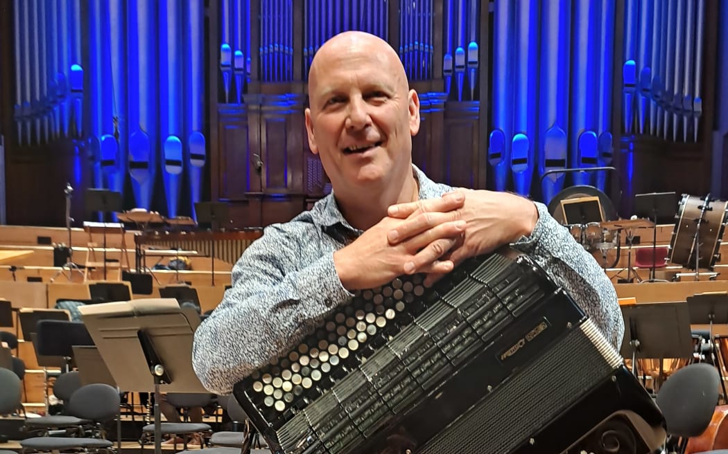 Accordion player James Crabb poses with his instrument on the stage of Auckland Town Hall