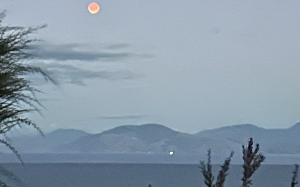 Jessica Le Bas captured this photo of the blood moon lunar eclipse from the cliffs at Ruby Bay, Tasman, on Friday 14 March, 2025.