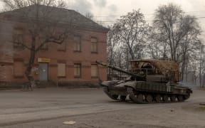 A Ukrainian tank drives on a road in a village in the Dnipropetrovsk region, on March 16, 2025, amid the Russian invasion of Ukraine. (Photo by Roman PILIPEY / AFP)