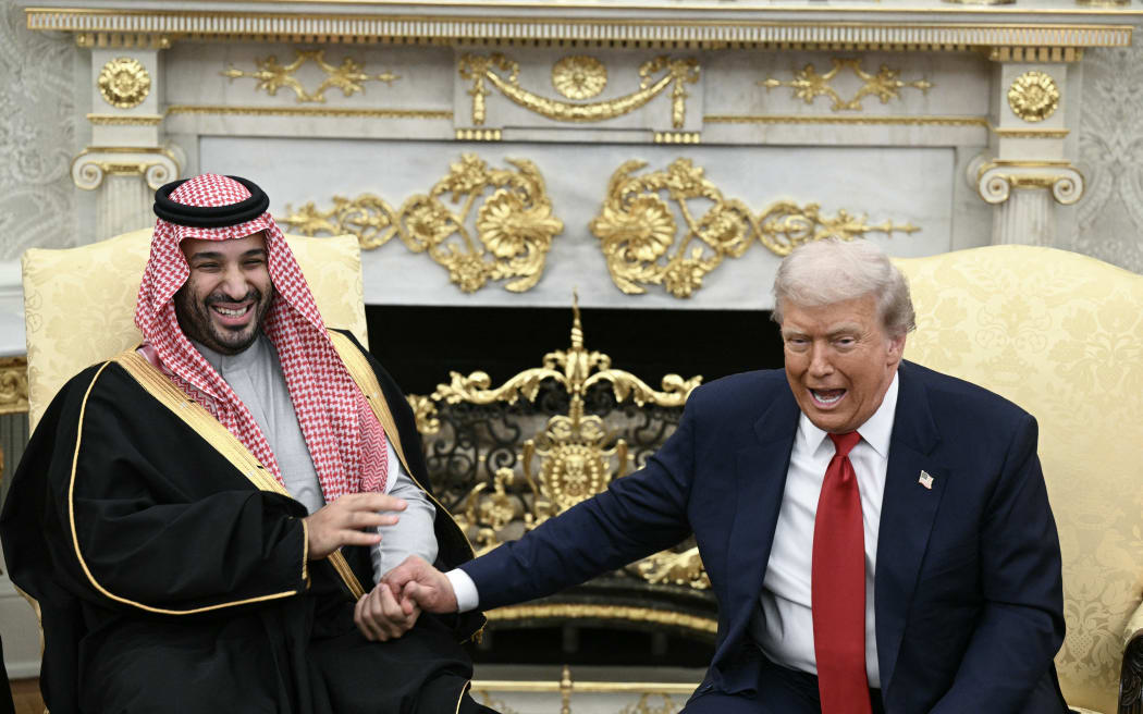 US President Donald Trump jokes about hand shakes and fist pumps with Crown Prince and Prime Minister of the Kingdom of Saudi Arabia Mohammed bin Salman during a meeting in the Oval Office of the White House in Washington, DC on 18 November, 2025.