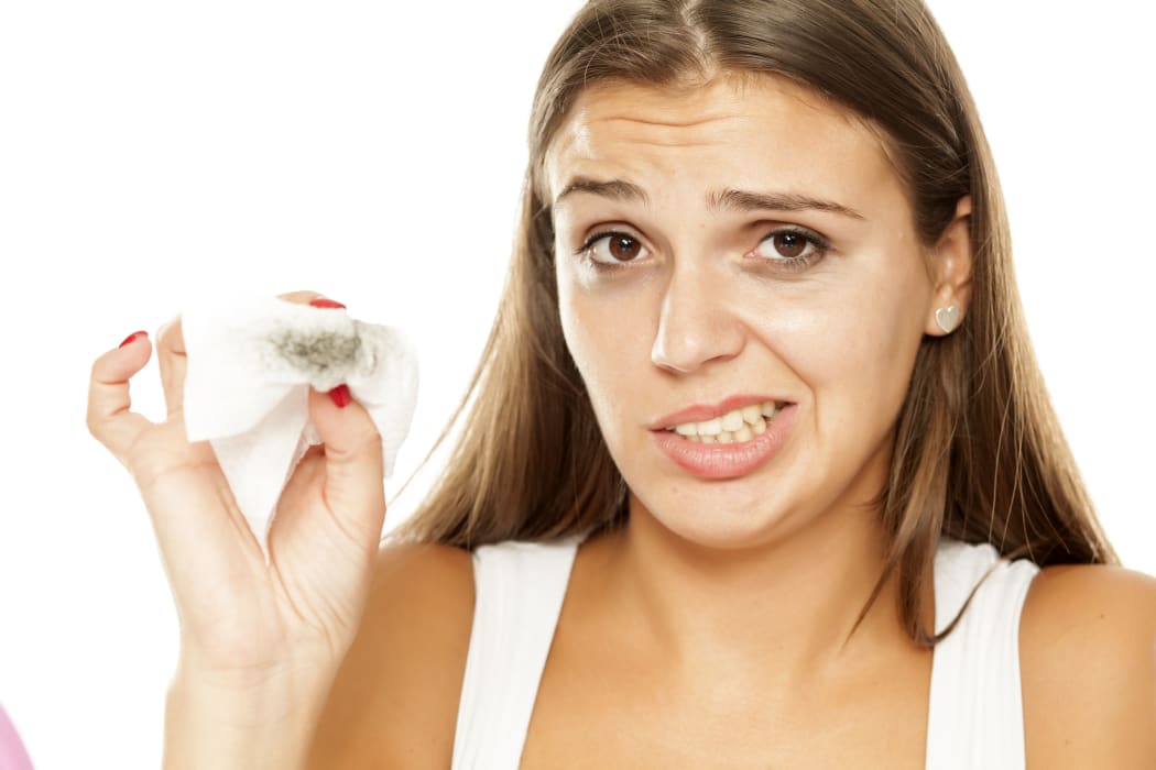 young beautiful woman removing makeup from her face