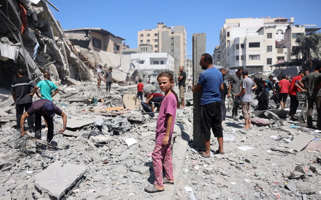 Palestinians walk past a destroyed building after an Israeli strike on Al-Nassr Street in Gaza City on September 12, 2025. Israel's military said on September 9 that it will act with "great force" in Gaza City and told residents to leave as it stepped up a deadly assault on the Palestinian territory's largest urban centre. (Photo by Omar AL-QATTAA / AFP)
