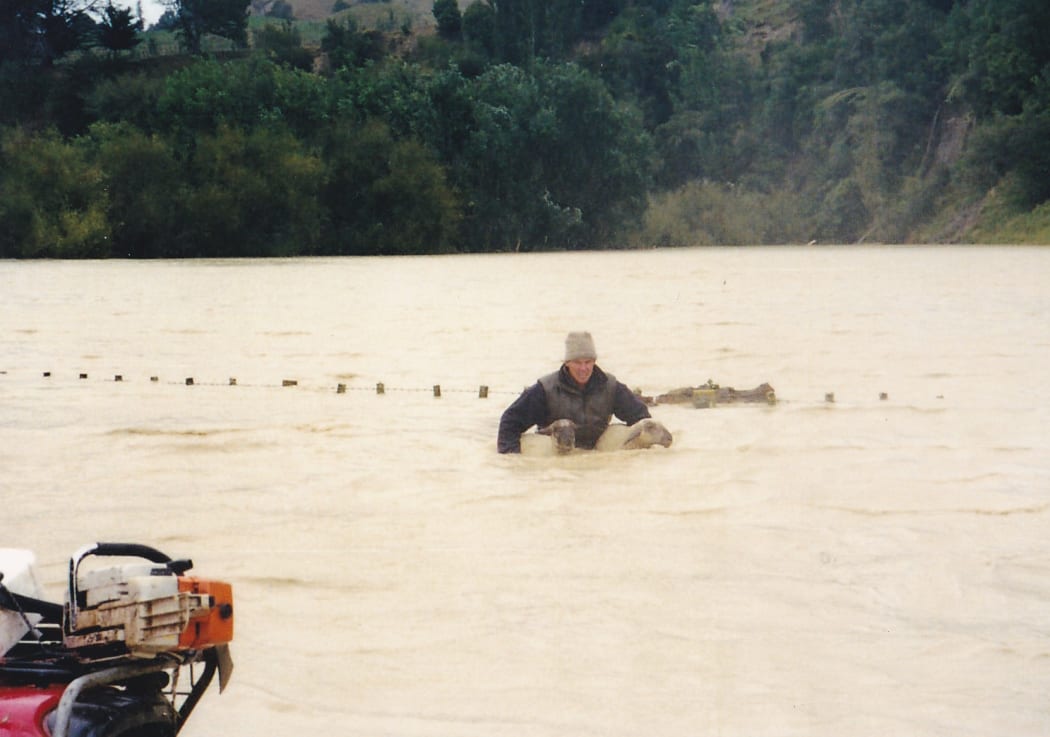 Mike Cranstone rescues sheep on his flooded farm in 2004.
