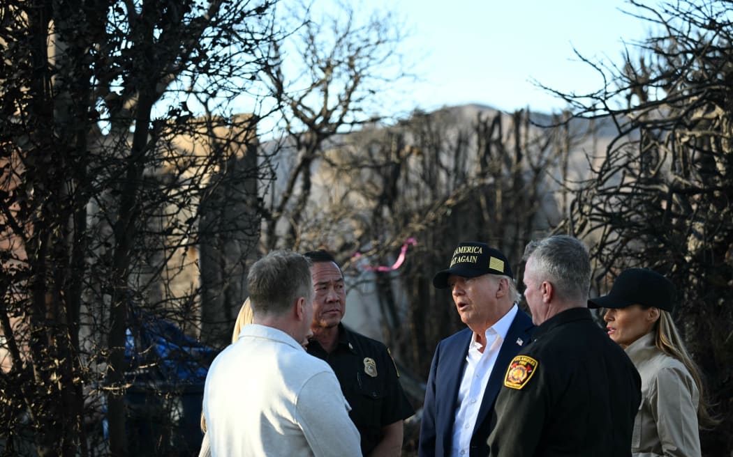 US President Donald Trump and First Lady Melania Trump speak with officials as they tour a fire-affected area in the Pacific Palisades neighborhood of Los Angeles, California, on 24 January, 2025.