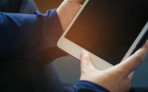 Woman's hands holding black tablet