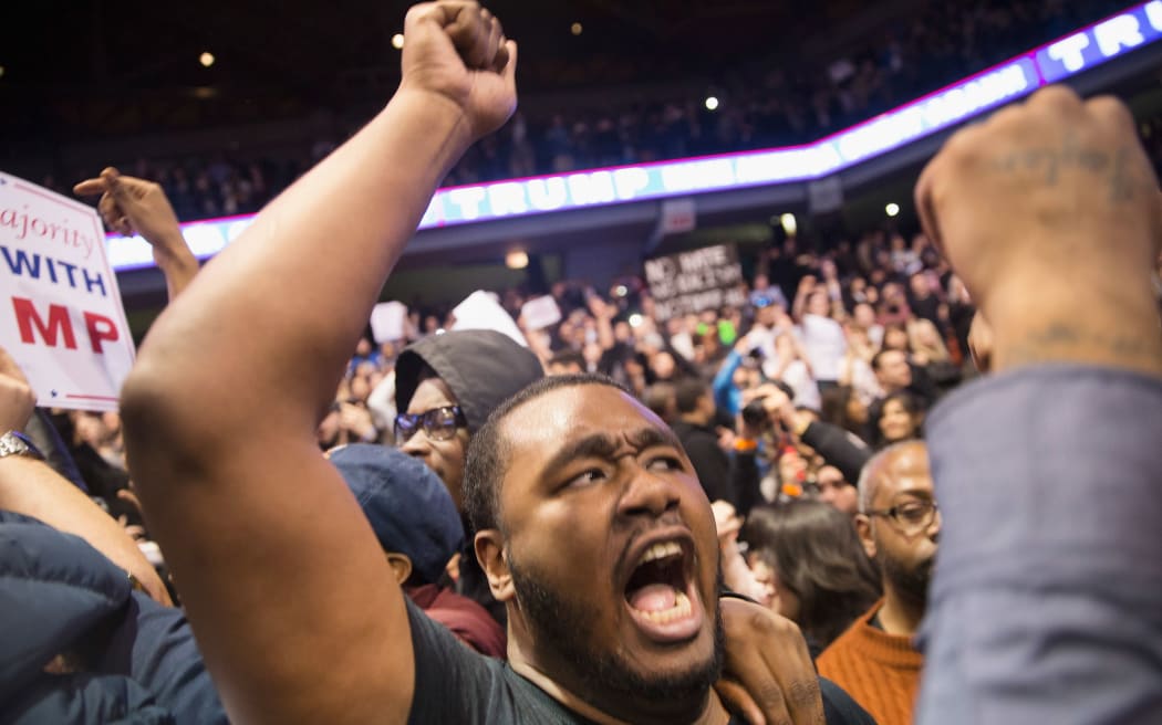 Demonstrators celebrate after Donald Trump's rallywas postponed.