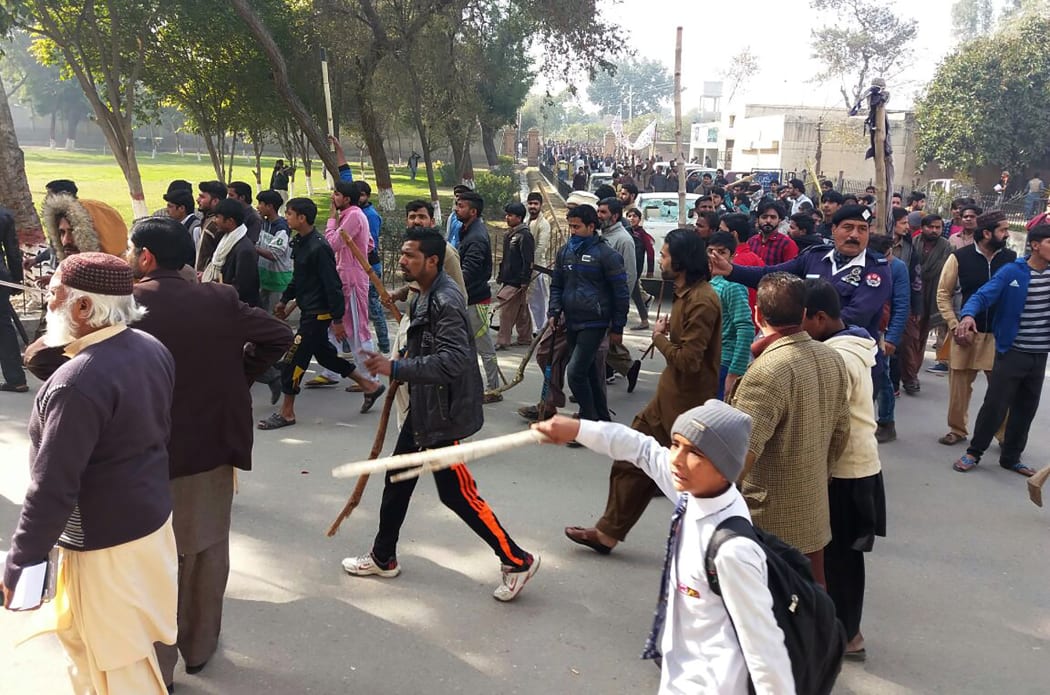Pakistani residents hold bamboo sticks as they stage a protest against the rape and killing of Zainab.