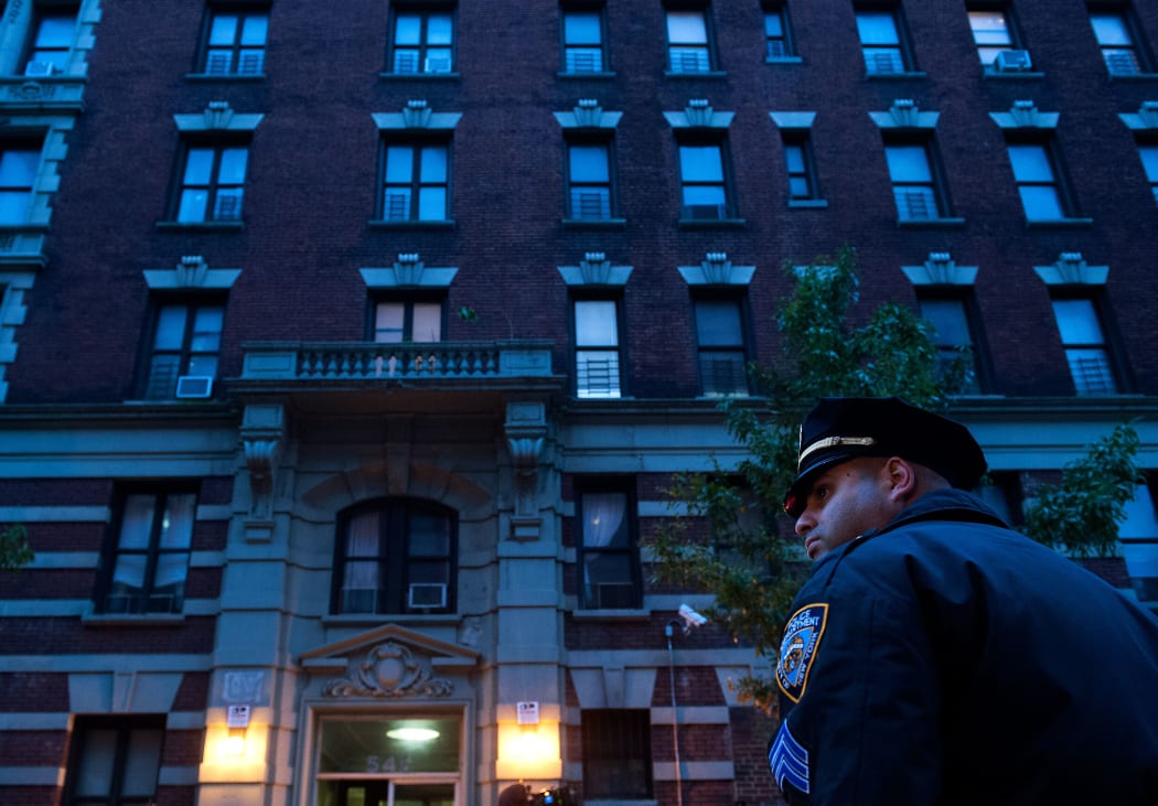 Police officers stand outside the apartment building of Dr. Craig Spencer in New York City.
