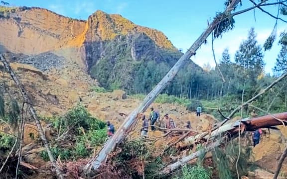 People gather at the site of a landslide in Maip Mulitaka in Papua New Guinea's Enga Province on May 24, 2024. Local officials and aid groups said a massive landslide struck a village in Papua New Guinea's highlands on May 24, with many feared dead.
