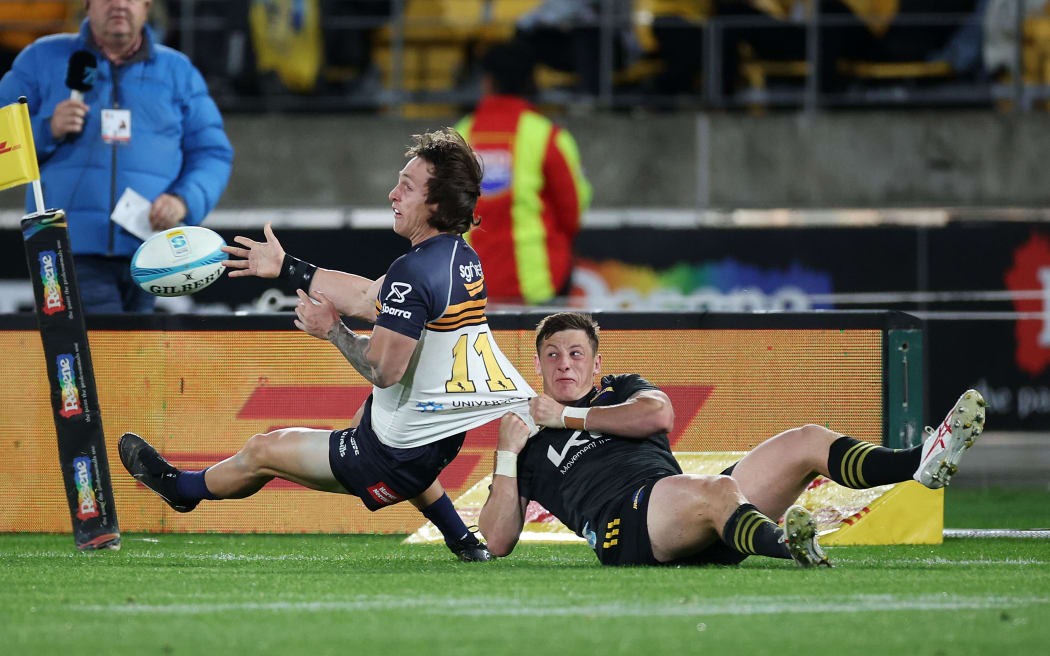 Brumbies' Corey Toole tackled by Hurricanes Cameron Roigard 2023.