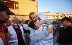 Palestinian hospital staff and well-wishers welcome the director of northern Gaza's Al-Awda Hospital Dr. Ahmad Mhanna, who was detained by Israeli forces from the hospital on December 18, 2023, following his release and arrival at the Nasser hospital in Khan Yunis in the southern Gaza Strip on October 13, 2025. (Photo by Omar AL-QATTAA / AFP)
