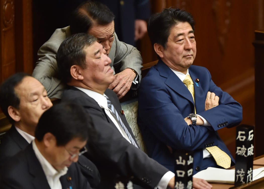 Japan's Prime Minister Shinzo Abe (right) and members of his cabinet attend a parliamentary session about the controversial security bills.