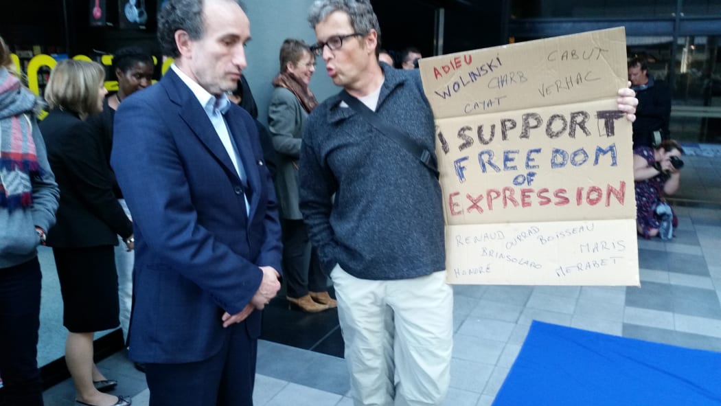 French ambassador Laurent Contini (left) talks with attendee at the Wellington vigil.
