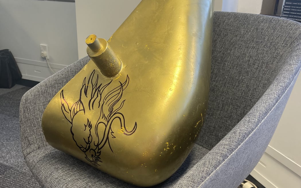 The bucket was found painted metallic gold and with a dragon illustration.