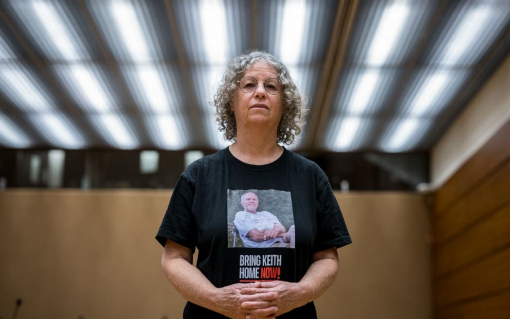 Former Hamas hostage Aviva Siegel poses with a t-shirt showing a picture of her husband Keith Siegel during an interview with AFP during her visit to the 55th session of the UN Human Rights Council in Geneva on February 28, 2024. Aviva Siegel was released on November 26, 2023, her husband is still being held hostage. (Photo by Fabrice COFFRINI / AFP)