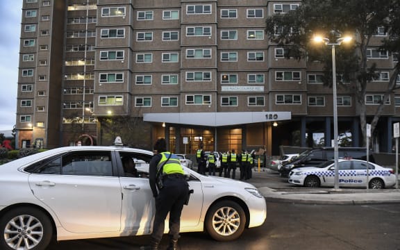 Police gather outside one of nine public housing estates which have been locked down in Melbourne.