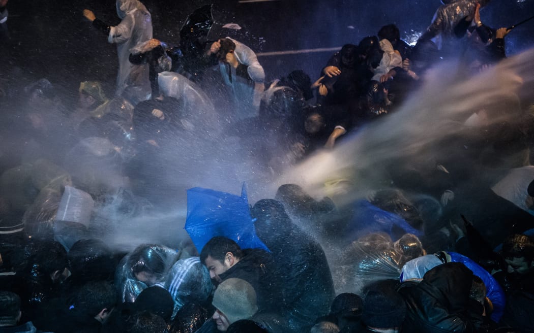 Turkish riot police use water cannons and tear gas to disperse supporters at Zaman daily newspaper headquarters in Istanbul on 5 March 5, 2016.