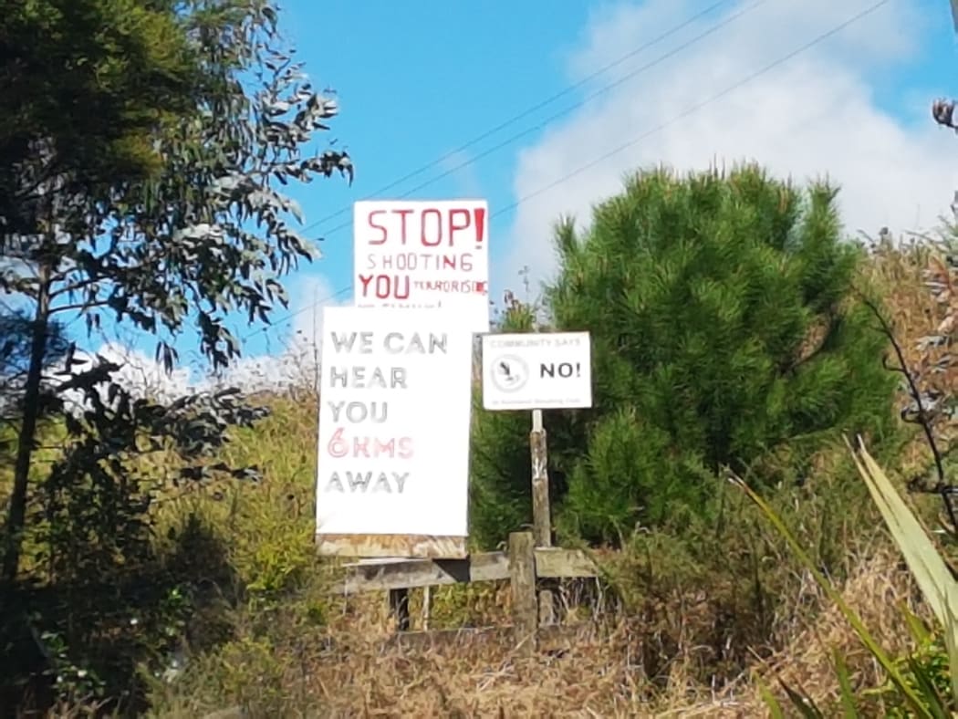 Protest signs near the gun club.