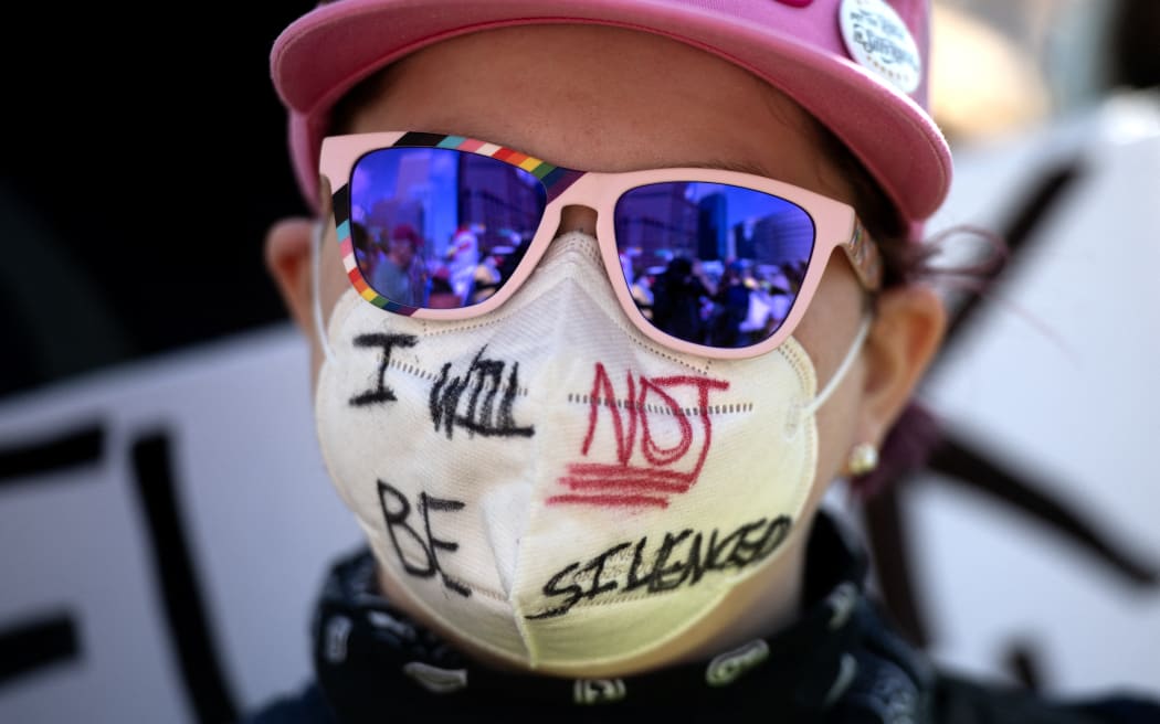 A demonstrator protests the Trump administration during the "No Kings" national rally in Denver, Colorado on October 18, 2025. From New York to San Francisco, millions of Americans are expected to hit the streets to voice their anger over President Donald Trump's policies at nationwide "No Kings" protests. (Photo by Jason Connolly / AFP)