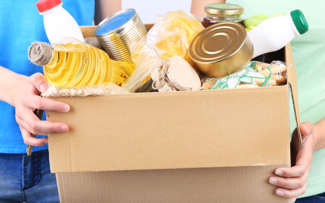 Volunteers with donation box with foodstuffs on grey background - food bank, foodbank