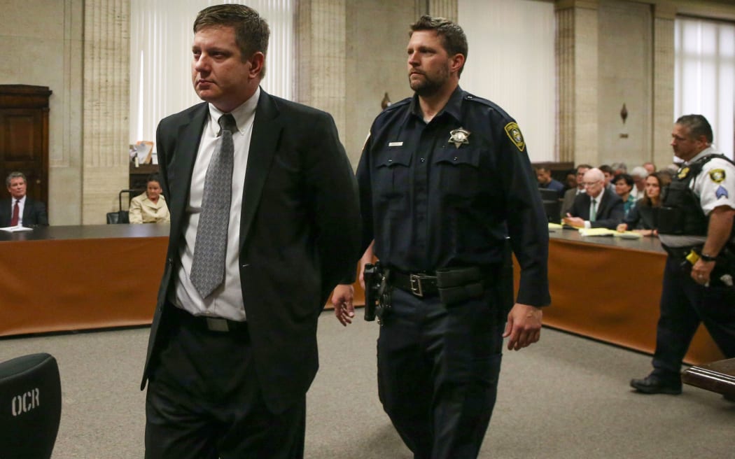 Police officer Jason Van Dyke (L) is led away at the Leighton Criminal Court in Chicago, October 5, 2018 following the guilty verdict for fatally shooting a black teen.